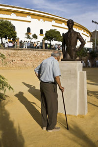 Rear view of man standing against wall