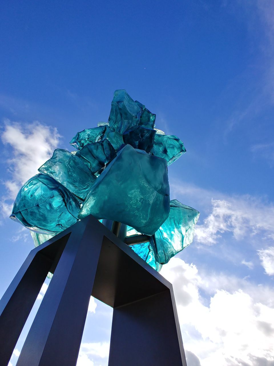 sky, low angle view, cloud - sky, blue, no people, sculpture, nature, day, statue, representation, art and craft, architecture, human representation, built structure, creativity, metal, turquoise colored, outdoors, green color, glass - material