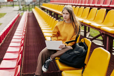 Young woman sitting on escalator