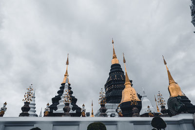 Low angle view of buildings against cloudy sky