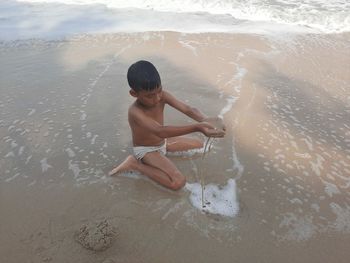 Full length of shirtless boy on beach