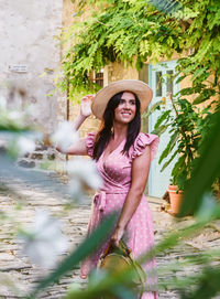 Elegant young woman in pink dress, old town, smile, happy, hat, one person.