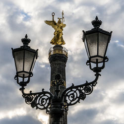 Low angle view of street light against cloudy sky