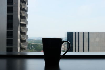 Close-up of coffee cup on table against window