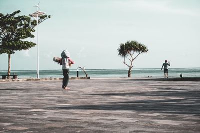 People at beach against sky
