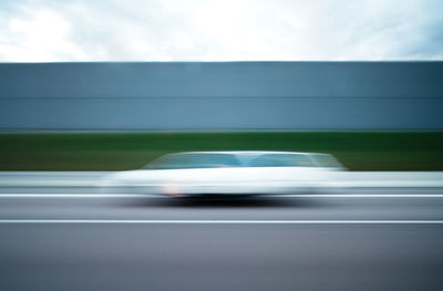 Blurred motion of car on road against sky