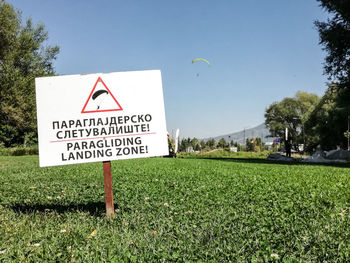 Information sign on field against clear sky