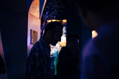 People looking at illuminated nightclub