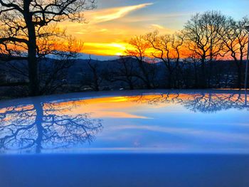 Scenic view of lake against orange sky during winter