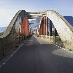 Bridge over road in city against sky