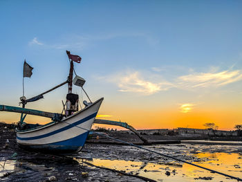 Ship moored on sea against sky during sunset