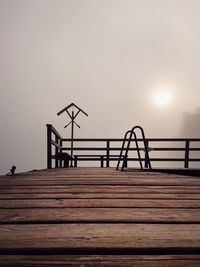 Silhouette pier against clear sky during sunset