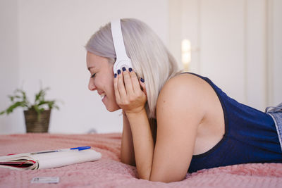 Midsection of woman lying on bed at home