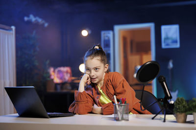 Portrait of young woman using laptop at home