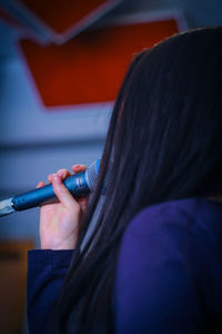 Close-up of woman holding microphone