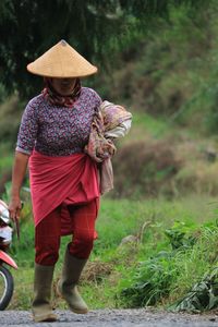 Rear view of woman standing by plants