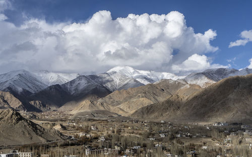 Aerial view of townscape and mountains against sky