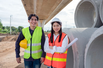 Portrait of a smiling young woman standing at construction site
