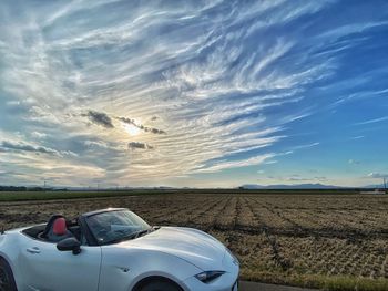 Cars on field against sky