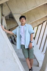 Full length of young man standing on staircase