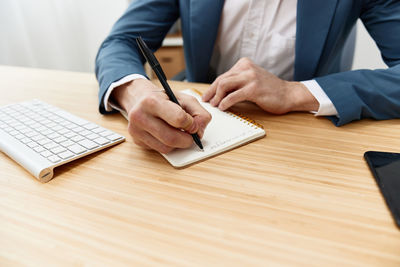 Midsection of businessman working on table