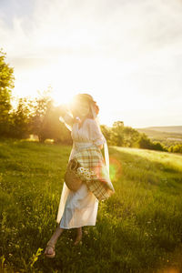 Rear view of woman standing on field