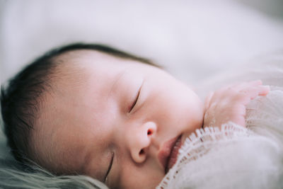 Close-up of baby sleeping on bed