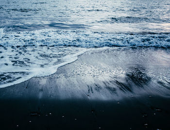 High angle view of waves rushing towards shore