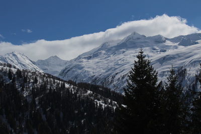 Scenic view of snow covered mountains against cloudy sky