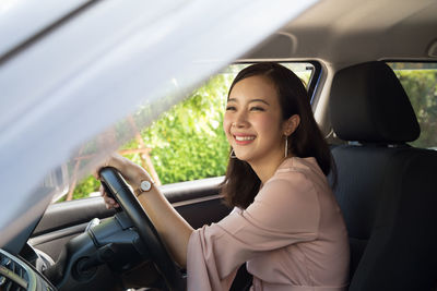 Portrait of smiling woman sitting in car