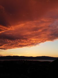 Scenic view of silhouette mountains against orange sky