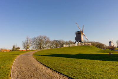 Windmill on field against clear sky