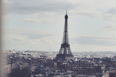 Eiffel tower against cloudy sky