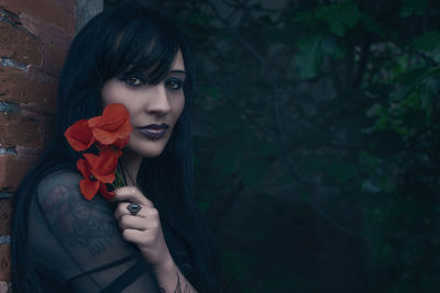 Portrait of young woman holding flower