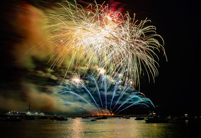 Firework display at night over water