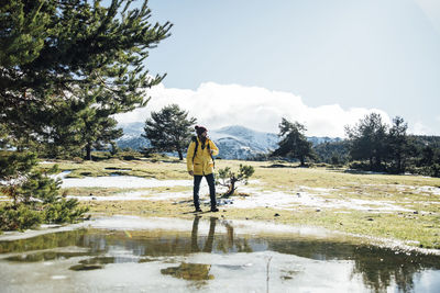 Rear view of man walking on snow covered land