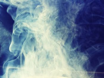 Close-up of smoke against blue sky