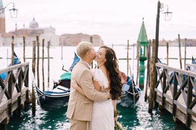 Couple standing on bridge over canal