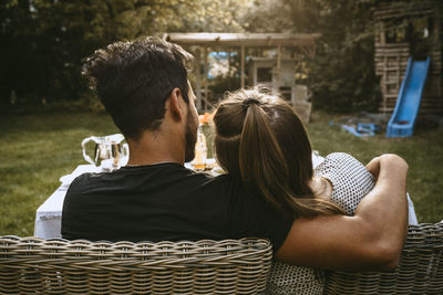 Rear view of couple sitting outdoors