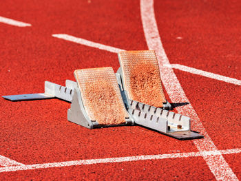 Side view of worn out starting blocks on running tracks. red tracks lanes at track and field stadium
