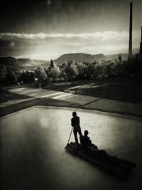 People relaxing on road against mountain range