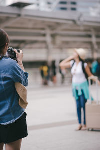 Rear view of woman photographing