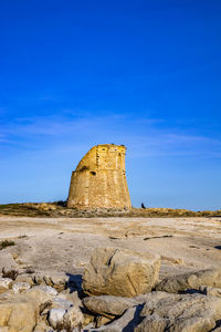 Rock formations on landscape against blue sky