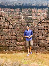 Full length of young man standing against wall