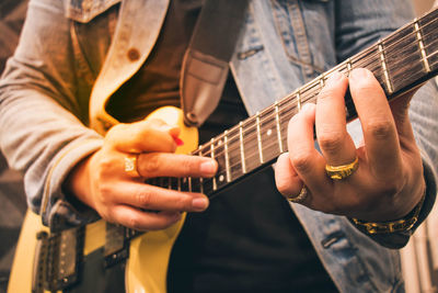 Midsection of man playing guitar