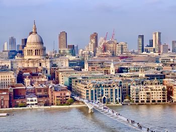 River amidst buildings in city against sky