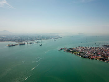 High angle view of city by sea against sky