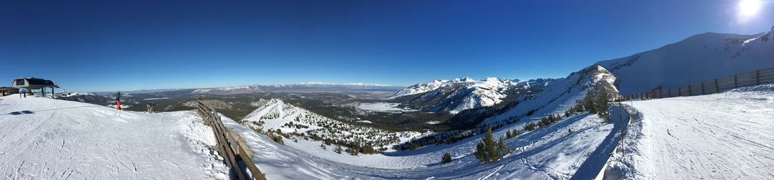 Panoramic view of snowcapped mountains against clear blue sky