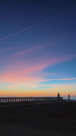 Scenic view of silhouette beach against sky during sunset