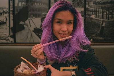 Purple hair asian woman eating a breadstick at the italian restaurant